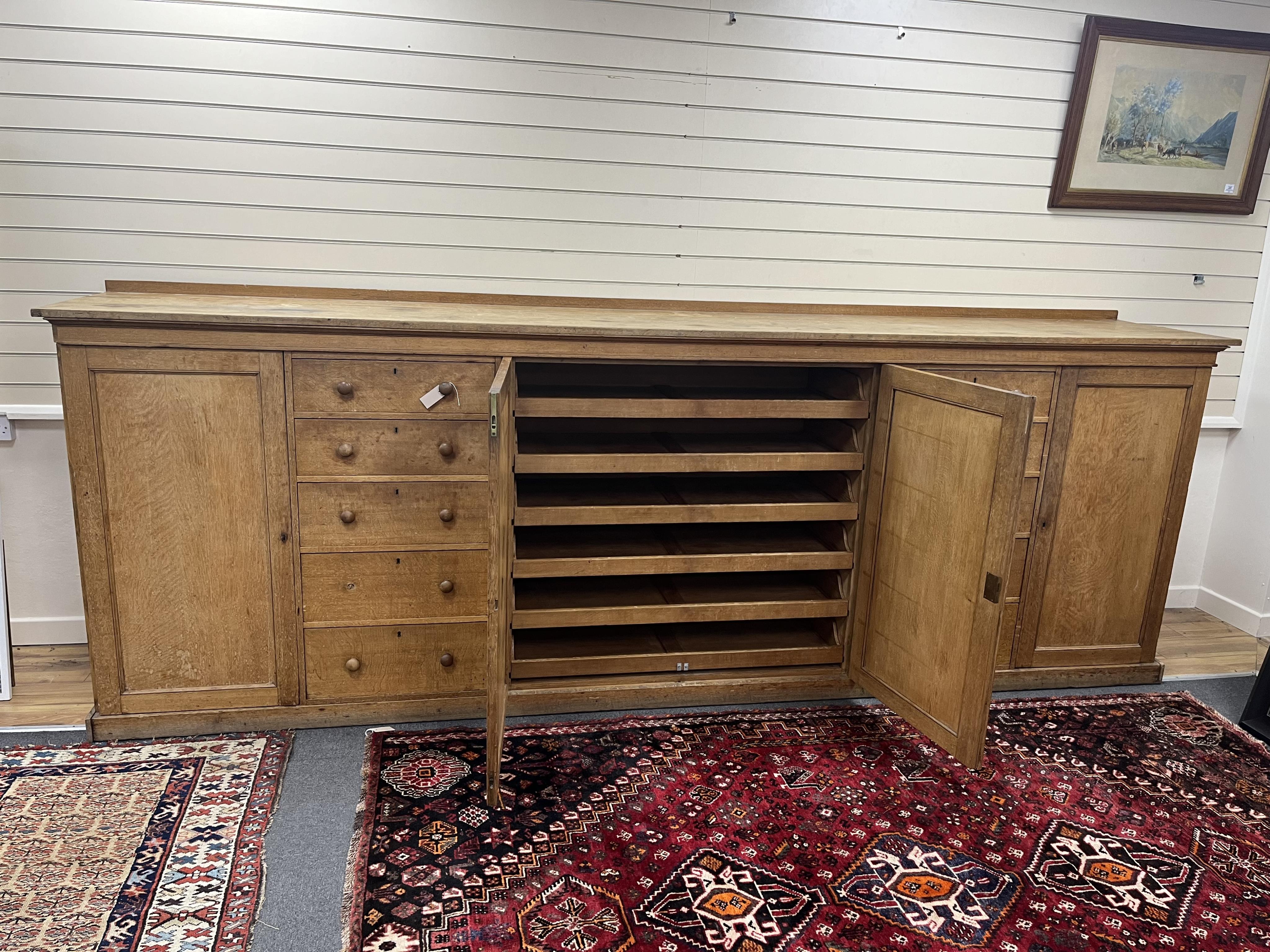 A late Victorian oak estate press cupboard, width 366cm, depth 64cm, height 130cm. Condition - fair